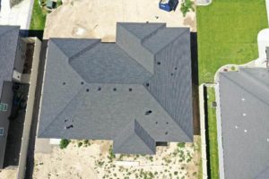 Top-down aerial overview of a house with a newly completed roof as a part of a roofing construction project in Twin Falls, Idaho.
